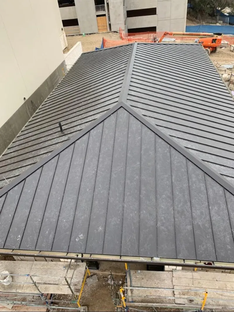 Commercial metal roof construction with crane equipment in Madison Heights